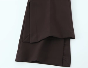 Gros plan détaillé de l'ourlet fendu latéralement sur un pantalon marron foncé