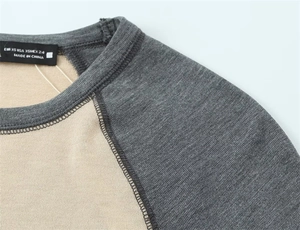 Détail des coutures contrastées des manches raglan et de l'étiquette sur un t-shirt