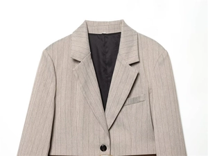 Nahaufnahme von taupefarbenem Nadelstreifen-Blazer mit elegantem braunem Ledergürtel