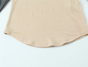 Détail de l'ourlet arrondi et des coutures contrastées d'un t-shirt raglan en tricot