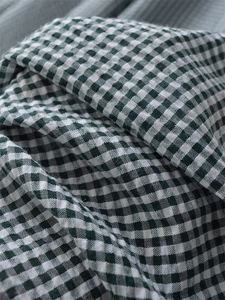 Dettaglio del tessuto vichy verde e bianco con una texture naturale in cotone e lino