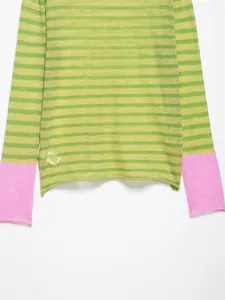 Détail d'un pull rayé vert montrant les poignets rose contrastés sur fond blanc neutre