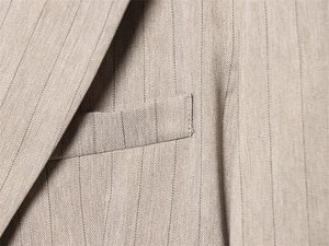 Makro-Detail des khakifarbenen Fischgrätmusters mit Nadelstreifen und feiner Naht am Blazer