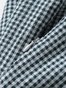 Dettaglio del tessuto vichy verde e bianco con una chiusura lampo invisibile liscia