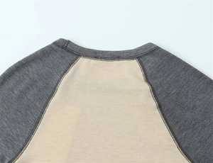 Détail du col et des manches raglan contrastées sur un t-shirt en maille de coton