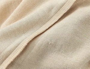 Détail macro des coutures de qualité et du tissu en maille douce sur un t-shirt raglan