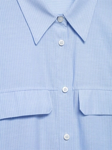 Dettaglio della camicia a righe azzurre con colletto classico e doppie tasche sul petto