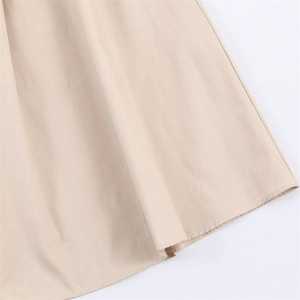 Détail de la texture du tissu de la robe midi beige et finition de couture de l'ourlet