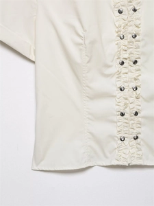 Détail d'une chemise à manches courtes en popeline avec volants et boutons pression