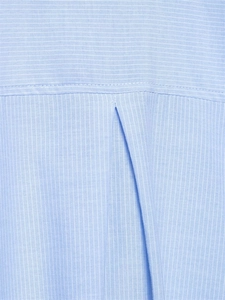 Dettaglio camicia a righe azzurre con pieghe a cannone e cuciture sullo sprone