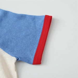 Detail der roten Rippbündchen am Ärmel und blaue Stofftextur auf einem Baumwoll-T-Shirt