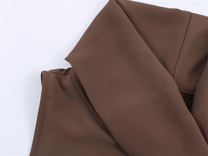 Detail of dark brown top showing sharp lapel collar and premium matte fabric texture