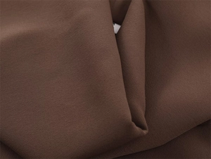 Close-up of deep brown textured fabric with natural draping and fine grain details