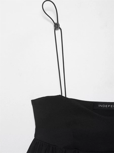 Detail of adjustable thin straps and metal buckle on this black balloon style camisole