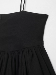 Detail of black strapless top showing sleek fabric with fine waist pleats and slim straps