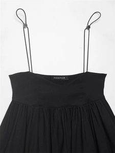 Detail of adjustable thin shoulder straps with silver metal slides on a black top