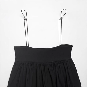 Minimalist black balloon-style camisole top with thin straps and silver buckle detail