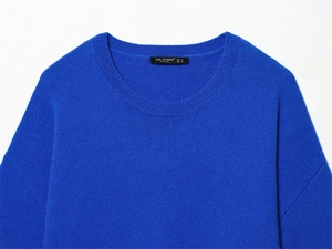 Gros plan du col d'un pull en maille bleu roi montrant l'étiquette et la texture douce