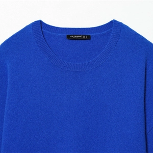 Gros plan du pull en maille bleu vif avec col rond et détails de tissage sophistiqués
