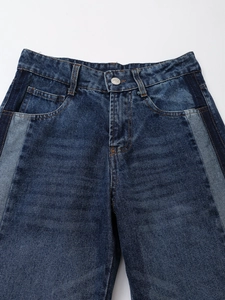 Detail von dunkelblauer Jeanshose mit kontrastierendem hellblauem Seiten-Patchwork