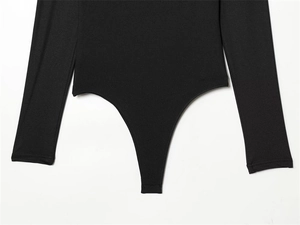 Detail shot of black long-sleeve slim-fit bodysuit with high-cut leg and reinforced seams
