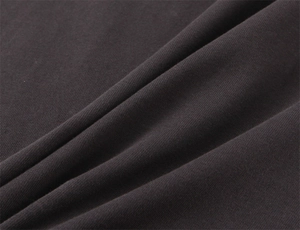 Macro shot showing soft knitted cotton fabric texture and premium drape of the dark t-shirt