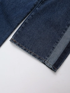 Makroaufnahme von dunkelblauen Denim-Jeans mit ausgefranstem Saum und Premium-Struktur