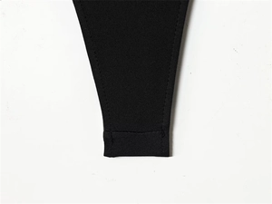 Macro detail of the double-stitched hem on black knitted fabric for a slimming bodysuit