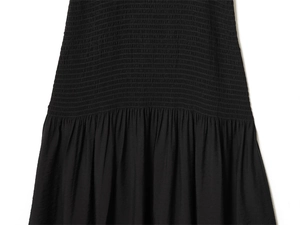 Close-up of black dress featuring elastic smocking craft and soft pleated fabric details