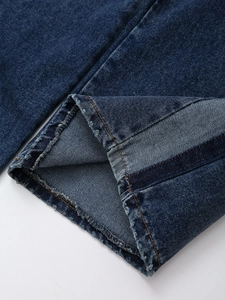 Makro-Detail des dunkelblauen Jeans-Beinabschlusses mit ausgefransten Kanten-Details
