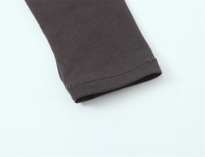 Detail of double-needle stitching on the cuffs of a slim-fit dark coffee long-sleeve tee