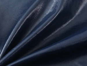 Vista macro della trama in pelle blu scuro e pieghe morbide sul tessuto della gonna