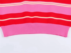 Détail de l'ourlet côtelé d'un pull polo en maille à rayures rouges, roses et jaunes