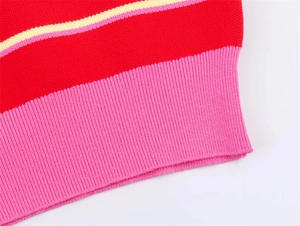 Détail macro du polo en maille à rayures rouges montrant les poignets côtelés roses