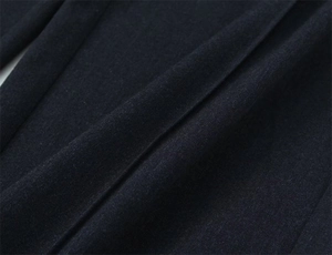 Dettaglio ravvicinato della trama in twill e della qualità del tessuto dei pantaloni blu