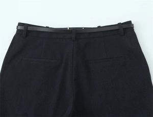 Dettaglio vita posteriore dei pantaloni neri con passanti e tasche a filetto