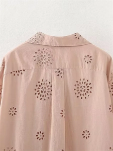 Dettaglio camicia rosa chiaro con ricamo floreale traforato e piega sulla schiena