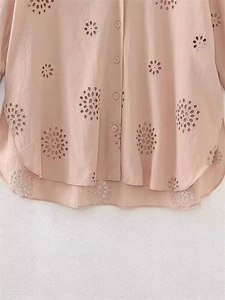 Dettaglio della camicia color albicocca con ricamo inglese e motivi floreali traforati