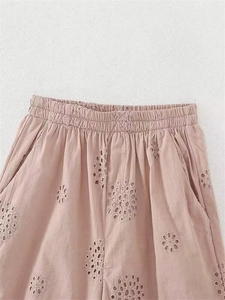 Detailaufnahme von Gummibund und feiner Ösenstickerei auf rosa Baumwoll-Shorts