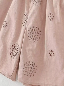 Detailansicht von rosa Baumwollstoff mit filigraner Blumenstickerei und Lochstickerei-Muster
