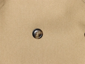 Macro shot of khaki slim fit blazer fabric with detailed twill weave and tortoiseshell button