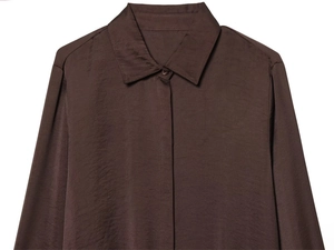 Détail d'une chemise en satin marron foncé avec col classique et tissu soyeux brillant