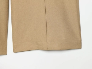 Close-up of khaki twill trousers showing high-quality hem stitching and fabric texture
