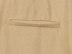 Detail of light khaki twill fabric and premium welt pocket on a slim fit suit jacket
