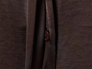 Détail macro d'une chemise en satin marron foncé avec bouton en résine et texture