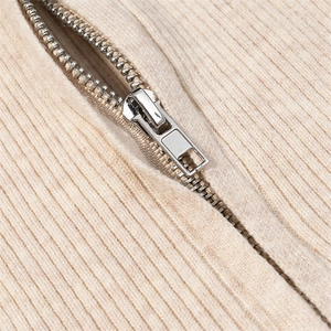 Close-up of premium silver metal zipper on beige ribbed corduroy long sleeve bodysuit