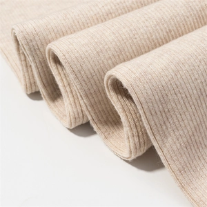 Close-up of beige ribbed knit fabric showing the soft wool texture and fine fibers