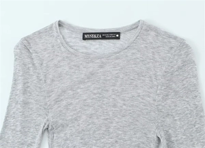 Detailed view of light gray knit fabric texture and neck label on long sleeve top