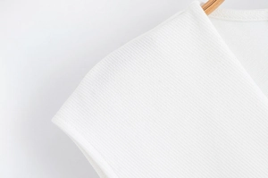 Gros plan détaillé du tissu de robe blanche à col en V avec épingle et texture tissée