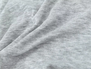 Macro view of grey melange knitted fabric texture with soft folds and high-quality fibers